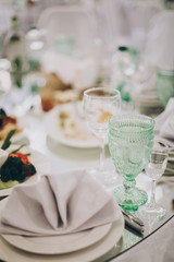 Wedding luxury table setting at reception in restaurant. Stylish glasses for wine, plate with napkin, cutlery and food on tables. Luxury catering service. Christmas feast