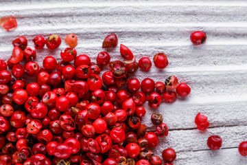 pink peppercorns on white wooden rustic background