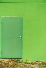 Grüne Eingangstür an grüner Wand