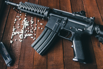 black metal airsoft rifle lying on a dark background