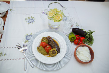 Eggplants are stuffed with meat lamb and rice. Patlican . eggplant filling . Eggplant, peppers, tomatoes . Yogurt in a brown bowl . Chopped lemon in a glass jar . Stuffed eggplant in the plate .