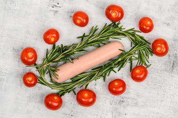 The sausage lies surrounded by cherry tomatoes