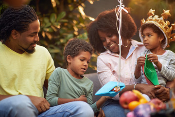 Loving afro family cuddling and smiling  at home. Enjoying and having fun together.