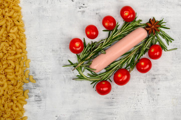 Fototapeta na wymiar The sausage lies surrounded by cherry tomatoes