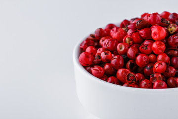fragrant pink peppercorns on white acrylic background