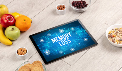MEMORY LOSS concept in tablet pc with healthy food around, top view