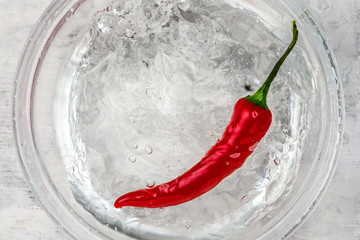 Chili pepper falls into water 