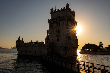 Silhouette of the Belem Tower in Lisbon illuminated by the setting sun.