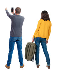 Back view of couple in sweater with mobile phone.