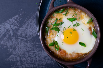 Garlic bread soup with egg baked in the oven in a portion saucepan