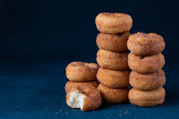 Cinnamon Sugar Mini Donuts in a stack on dark background with copy space
