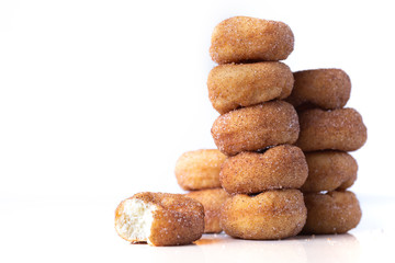 Cinnamon Sugar Mini Donuts in a stack on white background with copy space