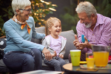 Multi generation family having fun.Grandparents playing  with  granddaughter.