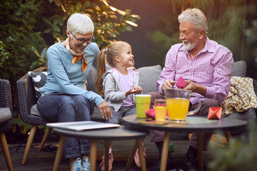 Cheerful girl spending good time with her  grandparents.