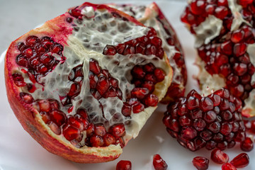 Closeup view of sliced pomegranate laying on concrete surface