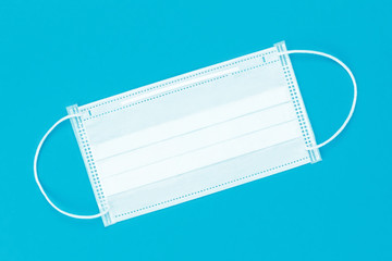 White medical mask on a blue background. Top view.