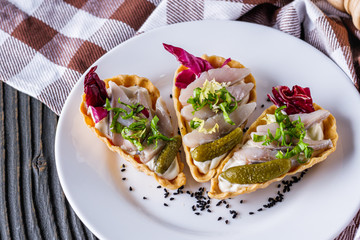 delicious snack tartlets on rustic wooden background