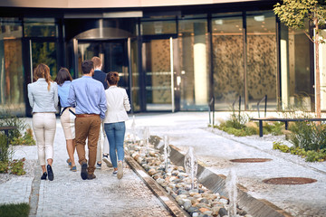 group of young employees entering the business building