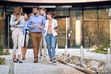 group of young businesspeople walking out of the building to have a break.