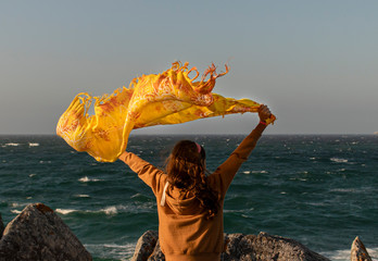 girl with scarf in the wind on the atlantic coast