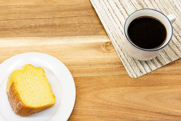 Piece of cake and black coffee on wooden table in cafe ,top view.