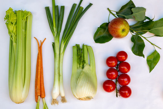 Flat lay with different kinds of fresh local vegetables en fruits like, celery, spring onion, tomato, apple, zucchini, chicory and fennel