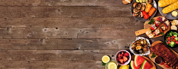 Poster Manger Barbecue d& 39 été ou bordure de coin de nourriture de pique-nique sur un fond de bannière en bois rustique. Viandes grillées assorties, légumes, fruits, salade et pommes de terre. Vue aérienne avec espace de copie.