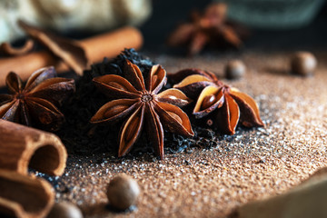 Anise stars with spices and black tea on a blue background. Recipe for tea masala.