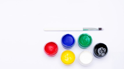 Set of colorful gouache jars and artist brush, white background,  copy space, 16:9