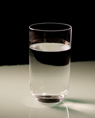 A glass of water isolated on white table with black background.
