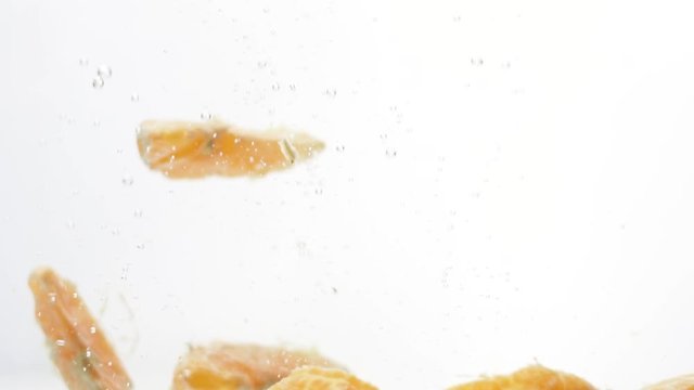 Slices of tangerines in an aquarium with water.
