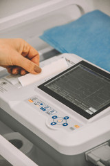 female doctor's hand next to a cardiogram device, medical concept, free space