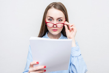 Teacher woman reads the essays of her students and takes off her glasses, portrait, white background