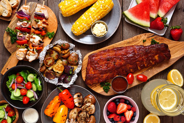 Summer BBQ or picnic food concept. Assortment of grilled meats, vegetables, fruits, salad and...