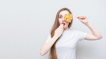 Shocked woman with lollipop in the shape of round, portrait, white background, 16:9