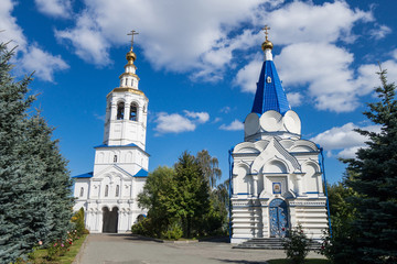 Fototapeta na wymiar Bell tower (left) & Temple of St.Vladimir (right) in Zilantov monastery complex, Kazan, Russia. It's one of most ancient places in city, found in 1552, & built in traditional orthodox Russian style
