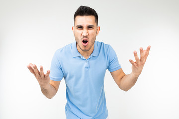Fototapeta premium handsome guy in a blue t-shirt screaming at the camera on a white isolated background