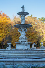 Fototapeta na wymiar antique stone ornamental fountain in a public park in Madrid. Spain