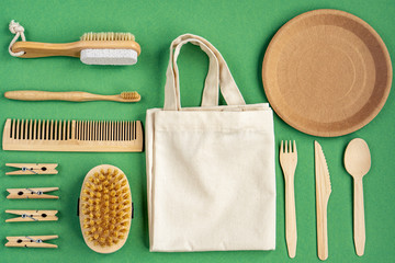 Zero Waste Cotton Bag. Zero waste concept. Textile eco bag, glass jars, wooden kitchen accessories, set for bathing on green background. Eco friendly and reuse concept. Top view, flat lay.