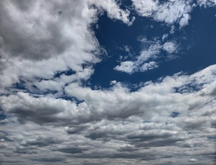 Low dark blue and blue sky with thunderous white-dark feather clouds