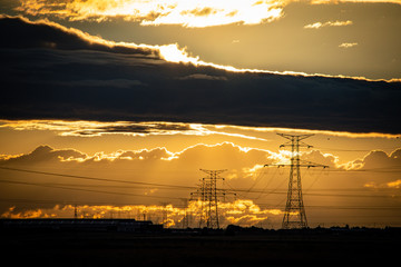 Fototapeta na wymiar sunset landscape with high voltage electricity pylons