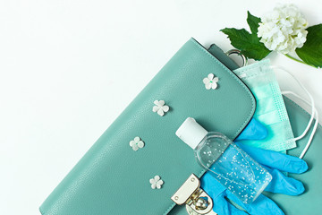 blue leather women bag with a medical mask, a sanitizer and gloves. Concept spring-summer 2020 exit from the coronavirus pandemic. protective equipment after isolation.