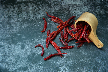 Red dried hot chilli pepper in the wooden spoon on gray texture background, Chilli is ingedient  of...