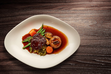 Stylish Nouvelle cuisine plate on wooden table