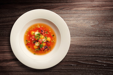 Bowl of vegetable soup on wooden background
