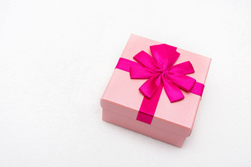 Gift with pink ribbon for Valentine's Day, white background, closeup, copy space, top view