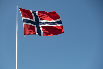 Norwegian national flag in strong wind, sunny, blue sky