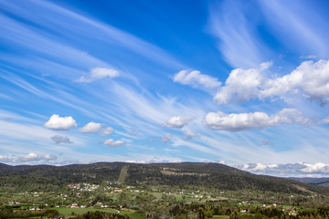 Obraz premium Cloudy and dramatic sky with green field and trees