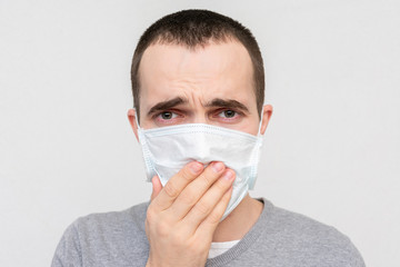 Man in a medical mask coughing, guy is ill, portrait, closeup