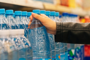 Closeup women's hands hold groceries in the store. The concept of buying fruits and vegetables in a hypermarket during quarantine